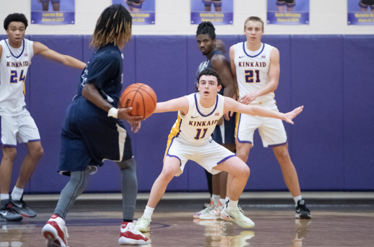 Juniors Ethan Williams, Jack Susman, and Ross Saunders play defense in a close game during the 2023-2024 season.